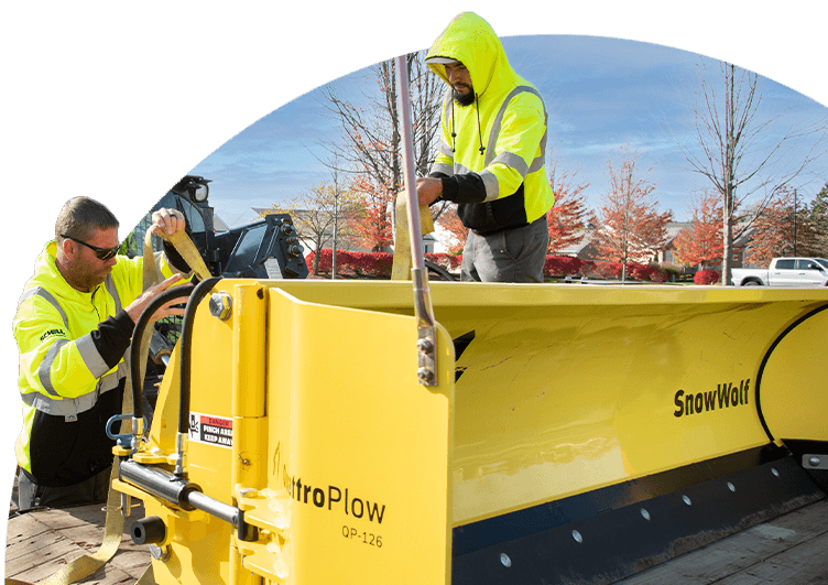 commercial landscaping professionals preparing a plow for snow removal
